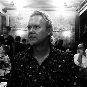 Photograph of author Bromme at restaurant table. Bromme is looking to the viewer's left.